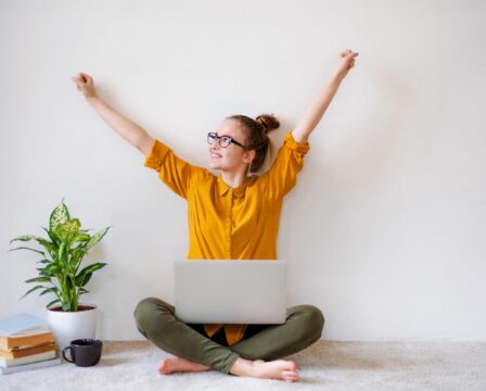 A young female student sitting on floor using laptop when studying.